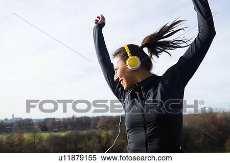 Woman in headphones dancing outdoors View Large Photo Image Stock Photography - Woman in headphones dancing outdoors. Fotosearch