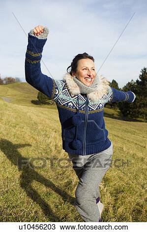 Woman in parka running in field View Large Photo Image Stock Image - Woman in parka running in field. Fotosearch