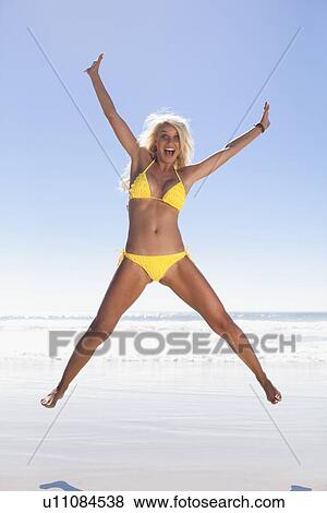Woman jumping for joy on beach View Large Photo Image Stock Photo - Woman jumping for joy on beach. Fotosearch