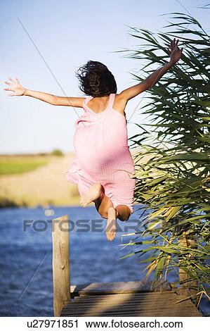 Woman jumping off dock into lake View Large Photo Image Stock Image - Woman jumping off dock into lake. Fotosearch