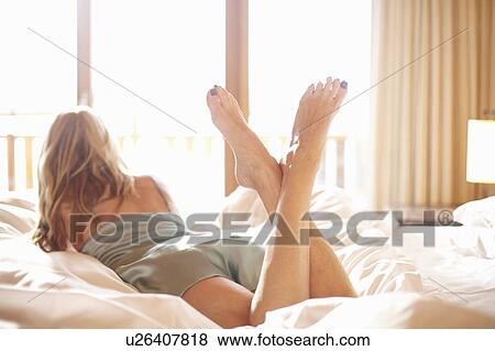 Stock Photo - Woman laying on bed. Fotosearch