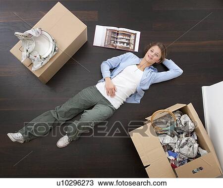 Stock Image - Woman laying on floor with boxes. Fotosearch