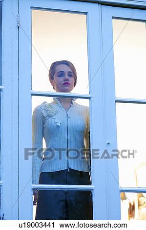 Woman looking out glass door View Large Photo Image Stock Image - Woman looking out glass door. Fotosearch