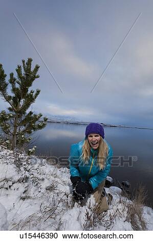Woman making snowball by lake View Large Photo Image Stock Image - Woman making snowball by lake. Fotosearch