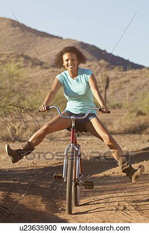Woman on bicycle in desert landscape View Large Photo Image Stock Image - Woman on bicycle in desert landscape. Fotosearch