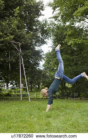 Stock Image - Woman playing in backyard. Fotosearch