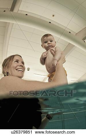 Woman playing with baby in pool View Large Photo Image Stock Image - Woman playing with baby in pool. Fotosearch