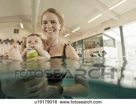 Woman playing with baby in pool View Large Photo Image Stock Photo - Woman playing with baby in pool. Fotosearch