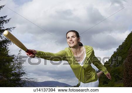 Woman playing with bat in rural field View Large Photo Image Picture - Woman playing with bat in rural field. Fotosearch
