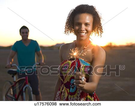 Woman playing with sparkler outdoors View Large Photo Image Stock Photo - Woman playing with sparkler outdoors. Fotosearch
