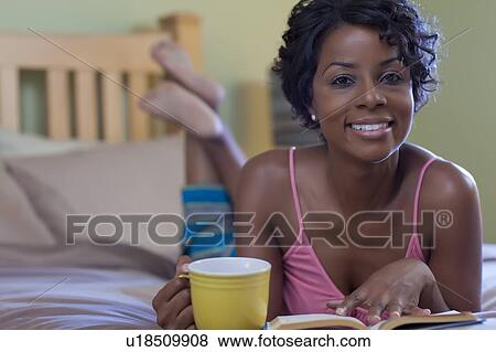 Woman reading with coffee on bed View Large Photo Image Stock Photo - Woman reading with coffee on bed. Fotosearch