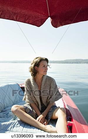 Woman relaxing in boat on still lake View Large Photo Image Stock Image - Woman relaxing in boat on still lake. Fotosearch