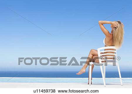 Woman relaxing in lawn chair by pool View Large Photo Image Stock Photo - Woman relaxing in lawn chair by pool. Fotosearch