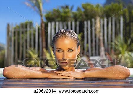 Picture - Woman relaxing on side of pool. Fotosearch