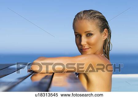 Woman relaxing on side of pool View Large Photo Image Stock Photography - Woman relaxing on side of pool. Fotosearch