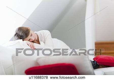 Woman relaxing on sofa in living room View Large Photo Image Stock Photo - Woman relaxing on sofa in living room. Fotosearch