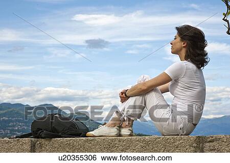 Woman relaxing on stone wall View Large Photo Image Stock Photograph - Woman relaxing on stone wall. Fotosearch