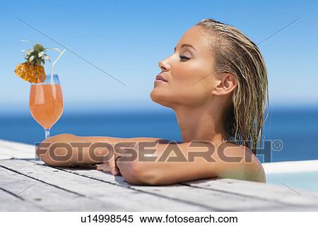 Woman relaxing with drink in pool View Large Photo Image Stock Photography - Woman relaxing with drink in pool. Fotosearch