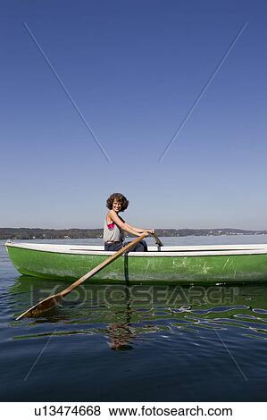 Woman rowing boat in still lake View Large Photo Image Stock Photo - Woman rowing boat in still lake. Fotosearch
