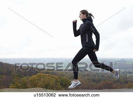 Woman running on rural hill View Large Photo Image Stock Image - Woman running on rural hill. Fotosearch