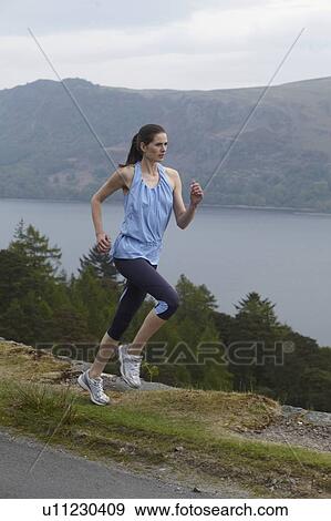 Woman running on rural hill View Large Photo Image Stock Photo - Woman running on rural hill. Fotosearch