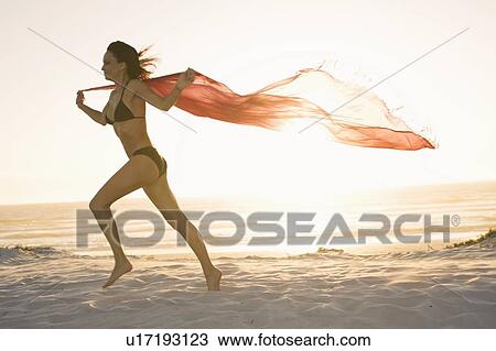 Woman running with sarong on beach View Large Photo Image Stock Image - Woman running with sarong on beach. Fotosearch