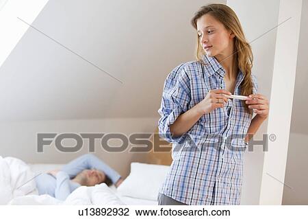 Woman secretly reading pregnancy test View Large Photo Image Stock Image - Woman secretly reading pregnancy test. Fotosearch