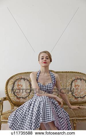 Woman sitting on ornate couch View Large Photo Image Stock Photo - Woman sitting on ornate couch. Fotosearch