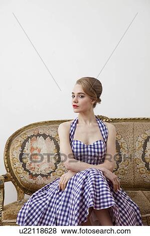 Woman sitting on ornate couch View Large Photo Image Stock Photo - Woman sitting on ornate couch. Fotosearch