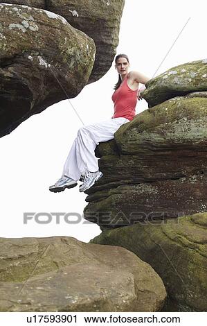 Woman sitting on rock formations View Large Photo Image Stock Image - Woman sitting on rock formations. Fotosearch