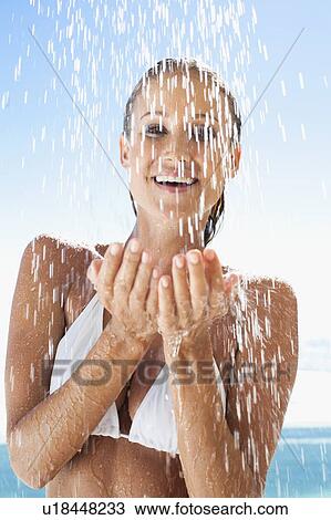 Stock Image - Woman splashing in swimming pool. Fotosearch