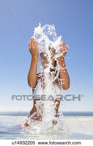Woman splashing in swimming pool View Large Photo Image Stock Photography - Woman splashing in swimming pool. Fotosearch