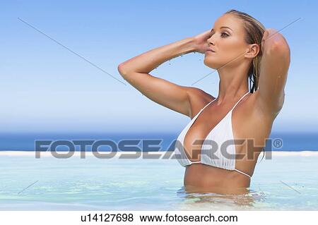 Woman standing in infinity pool View Large Photo Image Stock Photo - Woman standing in infinity pool. Fotosearch