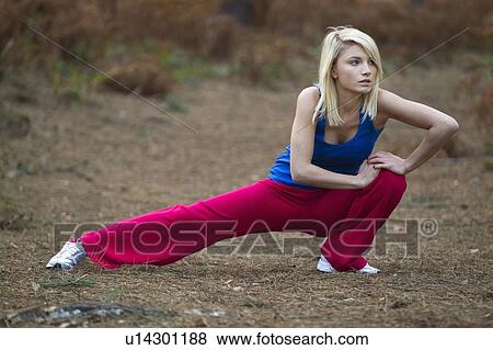 Stock Photo - Woman stretching in woods. Fotosearch
