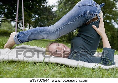 Woman stretching on blanket in grass View Large Photo Image Picture - Woman stretching on blanket in grass. Fotosearch