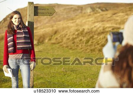 Woman taking picture of friend at post View Large Photo Image Stock Image - Woman taking picture of friend at post. Fotosearch