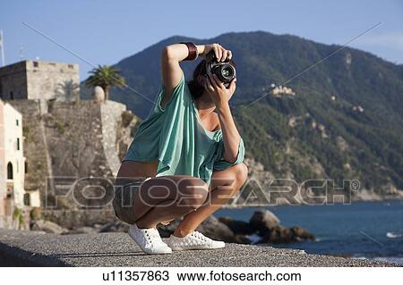 Woman taking pictures of coastline View Large Photo Image Stock Image - Woman taking pictures of coastline. Fotosearch
