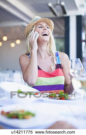 Stock Photography - Woman talking on cell phone in cafe. Fotosearch