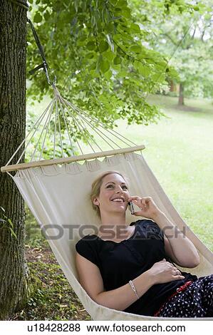 Woman talking on cell phone in hammock View Large Photo Image Stock Photo - Woman talking on cell phone in hammock. Fotosearch