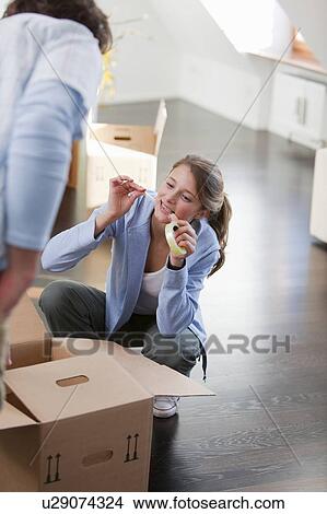 Picture - Woman taping up cardboard box. Fotosearch