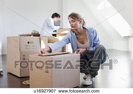 Woman taping up cardboard box View Large Photo Image Stock Photo - Woman taping up cardboard box. Fotosearch