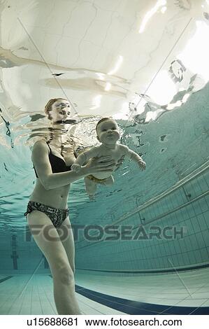 Woman teaching baby to swim in pool View Large Photo Image Stock Image - Woman teaching baby to swim in pool. Fotosearch