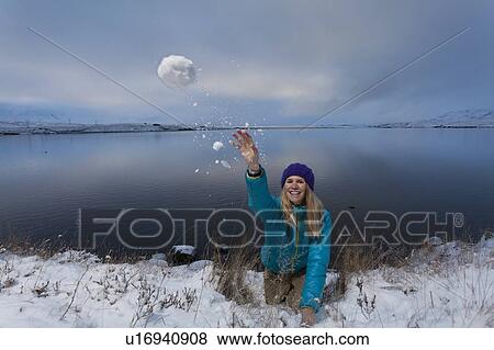 Woman throwing snowball by lake View Large Photo Image Stock Photo - Woman throwing snowball by lake. Fotosearch