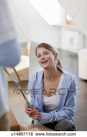 Stock Photo - Woman unpacking cardboard box. Fotosearch