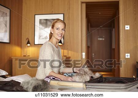 Stock Photo - Woman unpacking in hotel room. Fotosearch