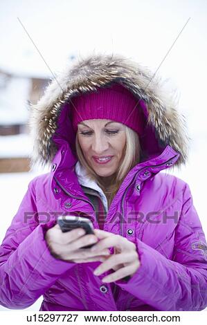 Woman using cell phone in snow View Large Photo Image Stock Photo - Woman using cell phone in snow. Fotosearch
