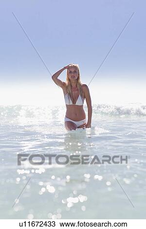 Woman walking in waves on beach View Large Photo Image Stock Image - Woman walking in waves on beach. Fotosearch