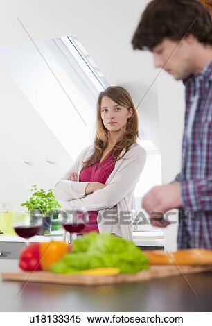 Woman watching boyfriend cook View Large Photo Image Stock Photography - Woman watching boyfriend cook. Fotosearch