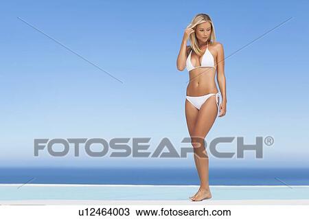 Woman wearing bikini by infinity pool View Large Photo Image Stock Image - Woman wearing bikini by infinity pool. Fotosearch