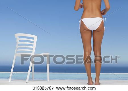 Woman wearing bikini by infinity pool View Large Photo Image Stock Photo - Woman wearing bikini by infinity pool. Fotosearch